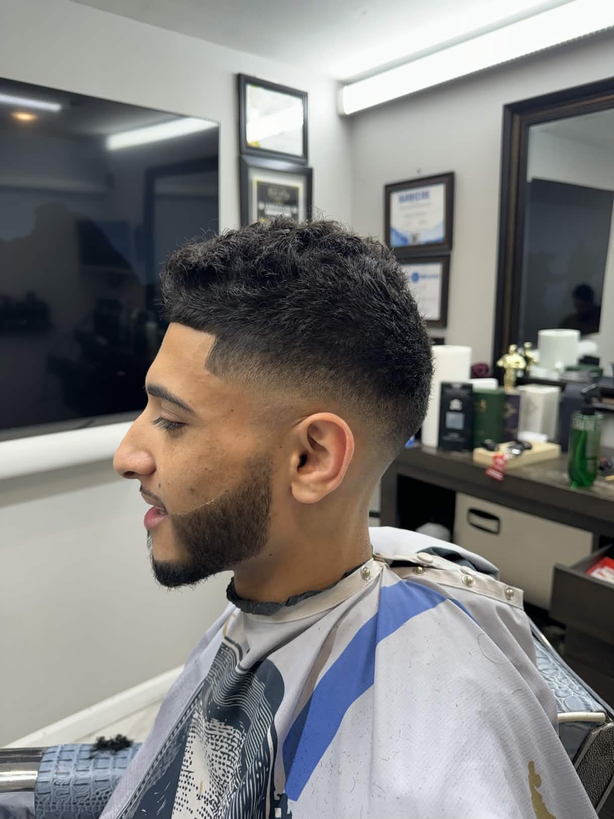 Textured crop + mid fade + beard shape by Kevin at Caveman's Den