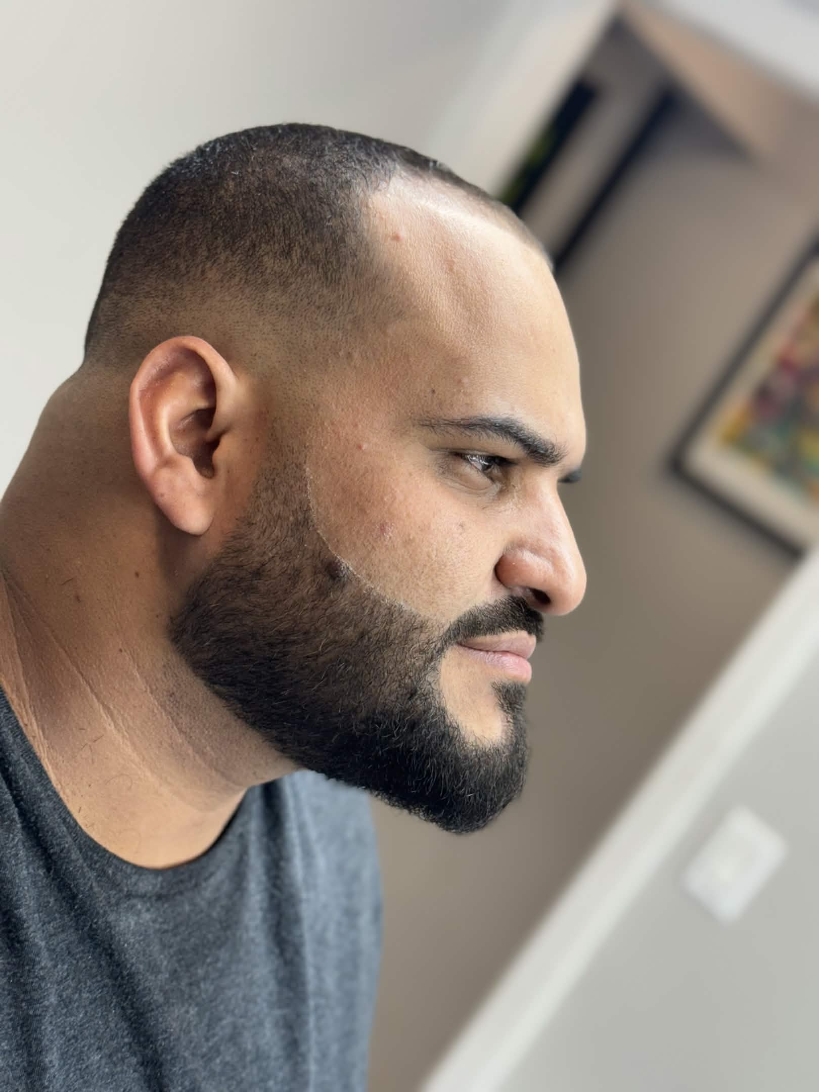 Low fade with neat beard trim — side profile at Caveman's Den Astoria