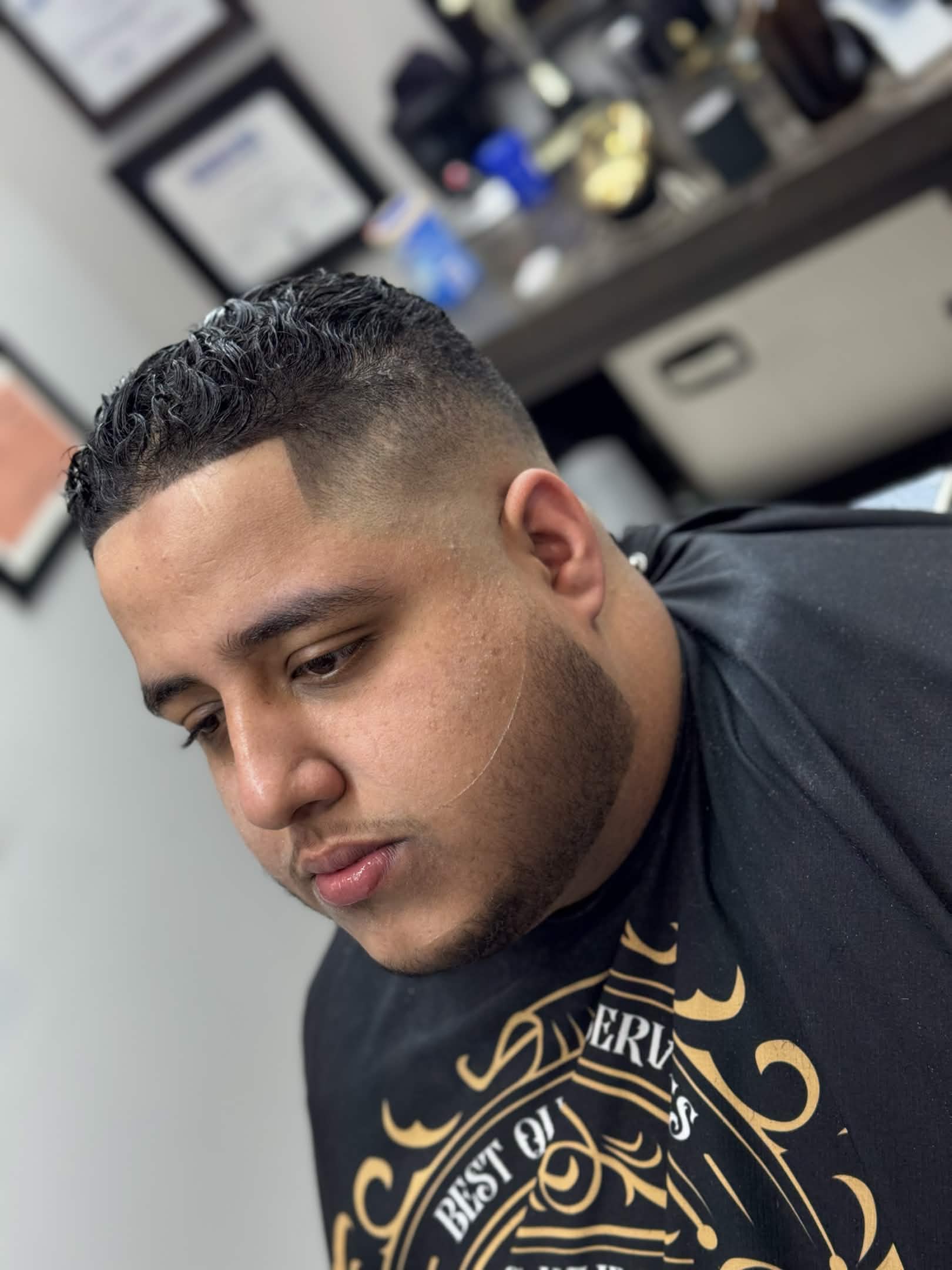 Textured curly top with taper fade at Caveman's Den barbershop