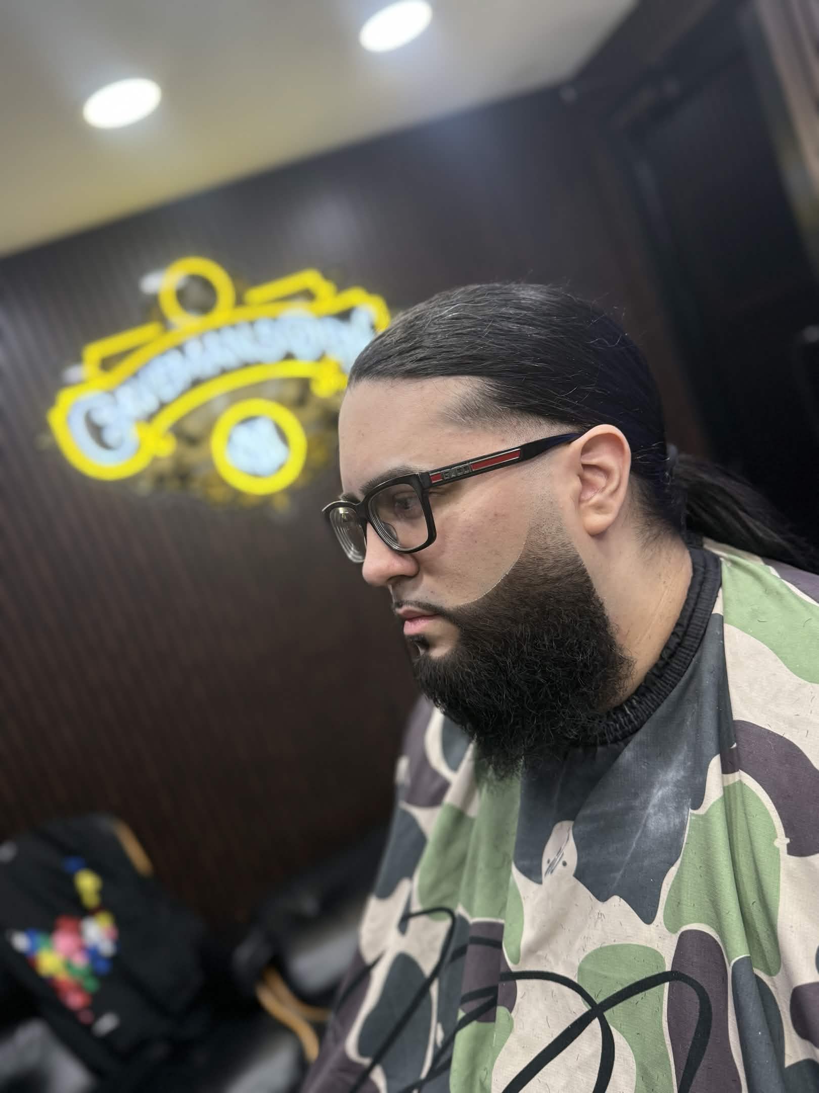 Long hair pulled back with beard lineup — Caveman's Den Barbershop
