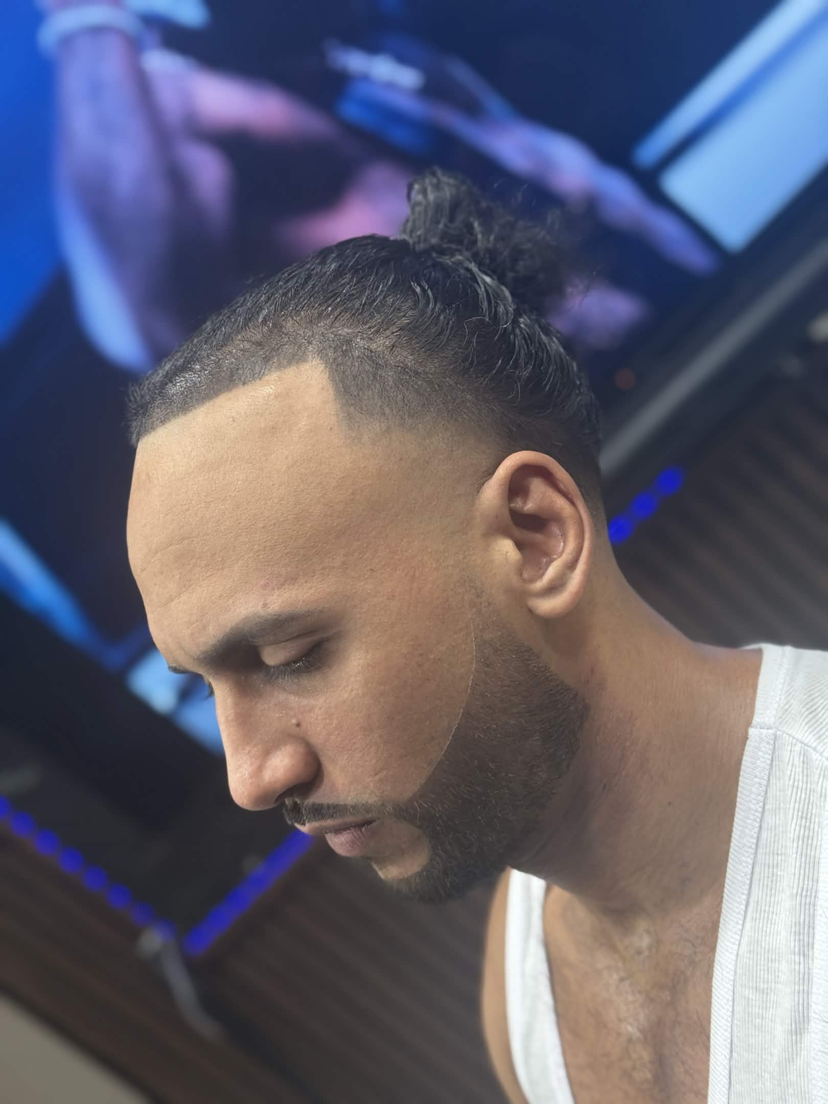 Top knot bun with taper fade and beard shape by Kevin