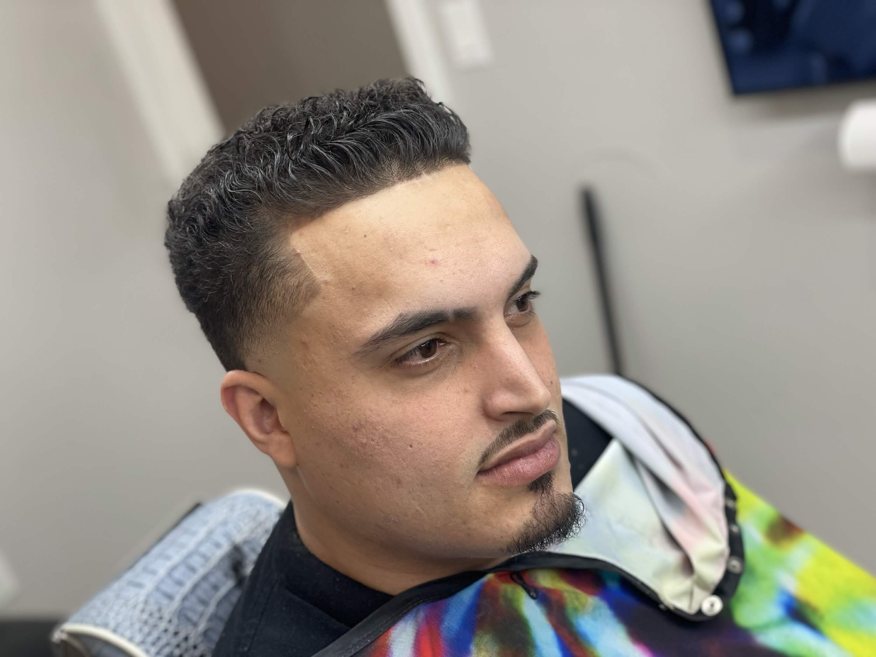Curly taper fade with beard at Caveman's Den Astoria NY