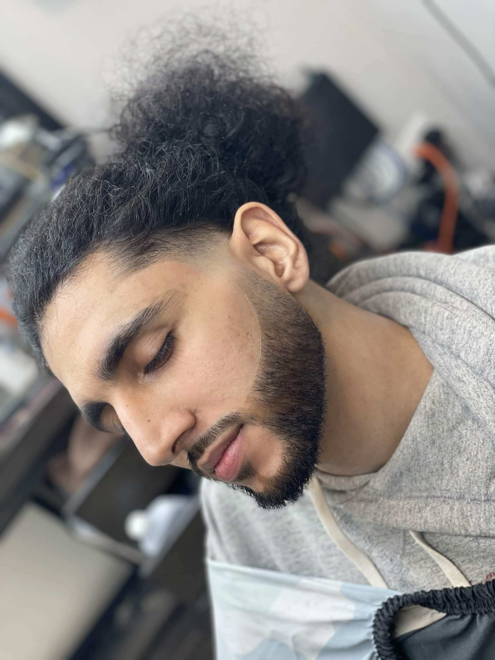 Curly top with taper fade and beard trim by Kevin at Caveman's Den